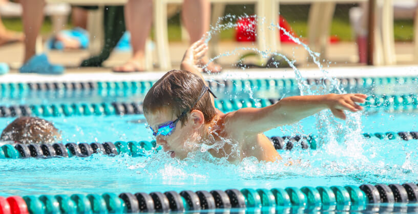 swim instructor and student during swim lessons in pool