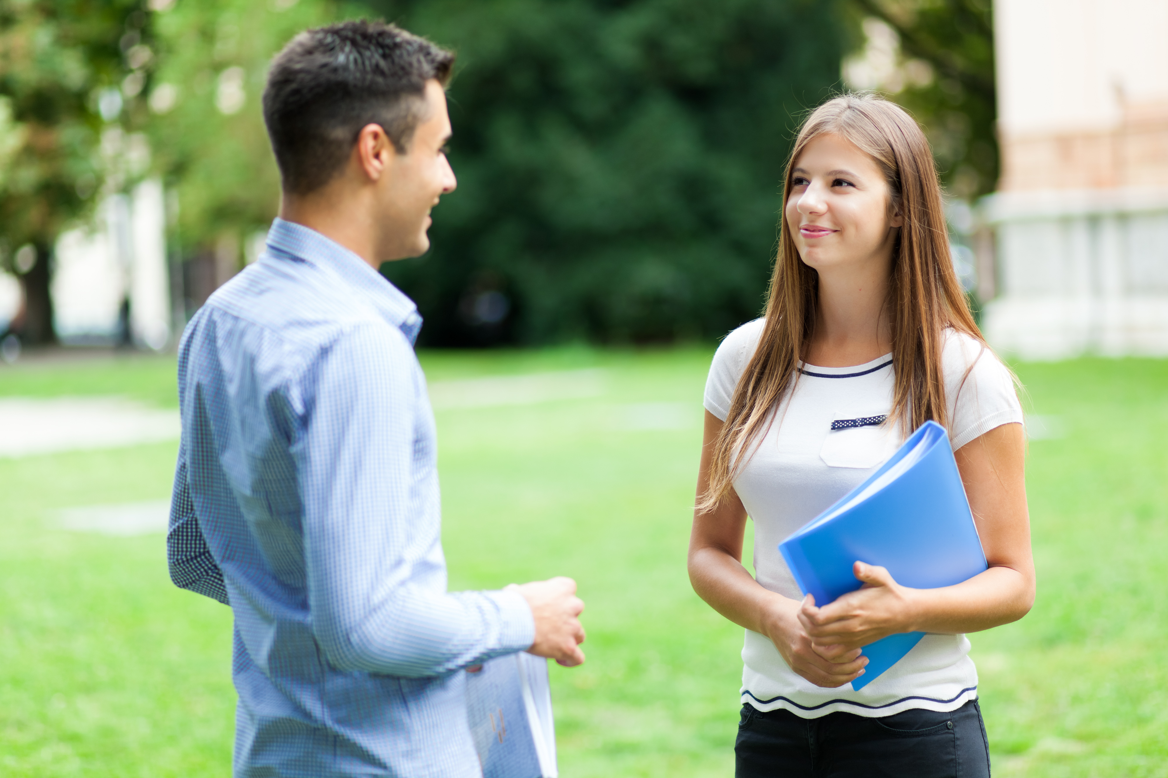 Man and woman giving feedback to one another outside.