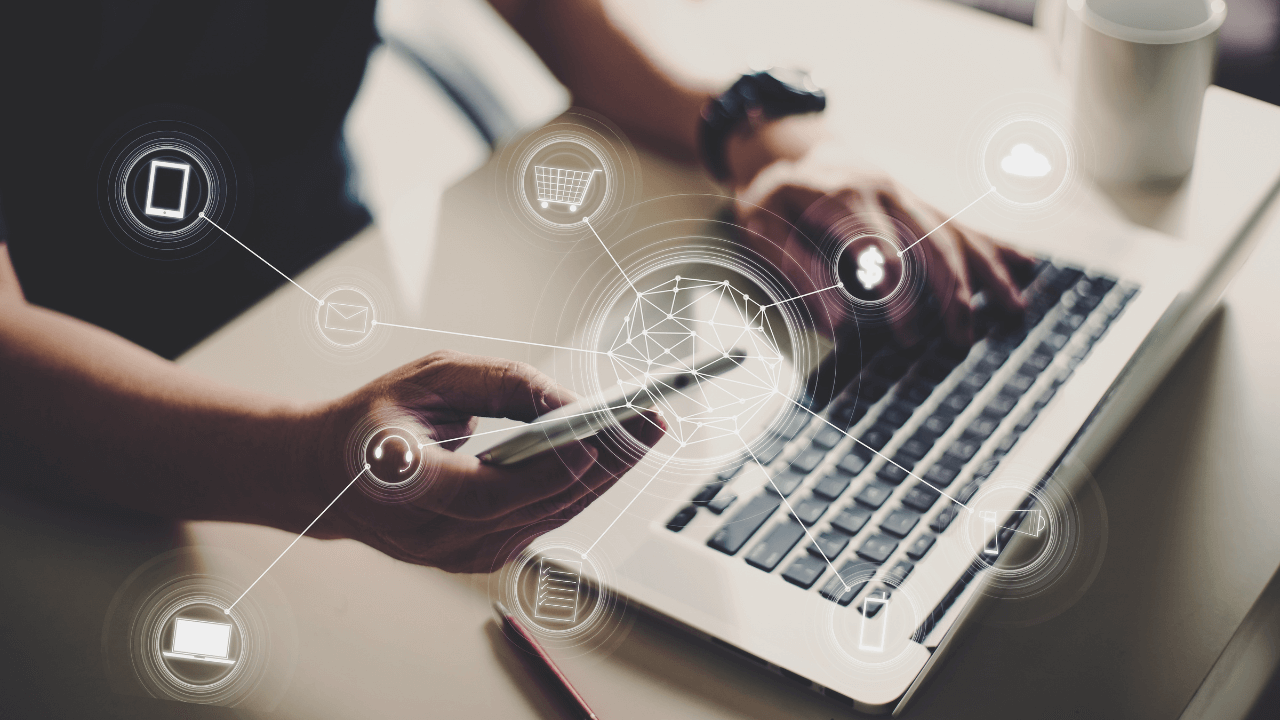 person holding a cellphone and typing on a laptop with an overlay web chart